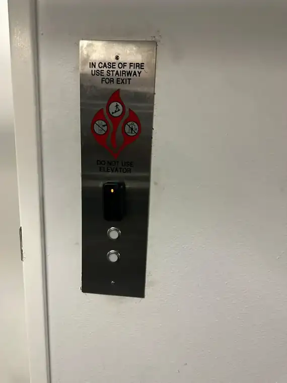 Elevator hall-call panel with a proximity card reader installed at a parking-level elevator lobby